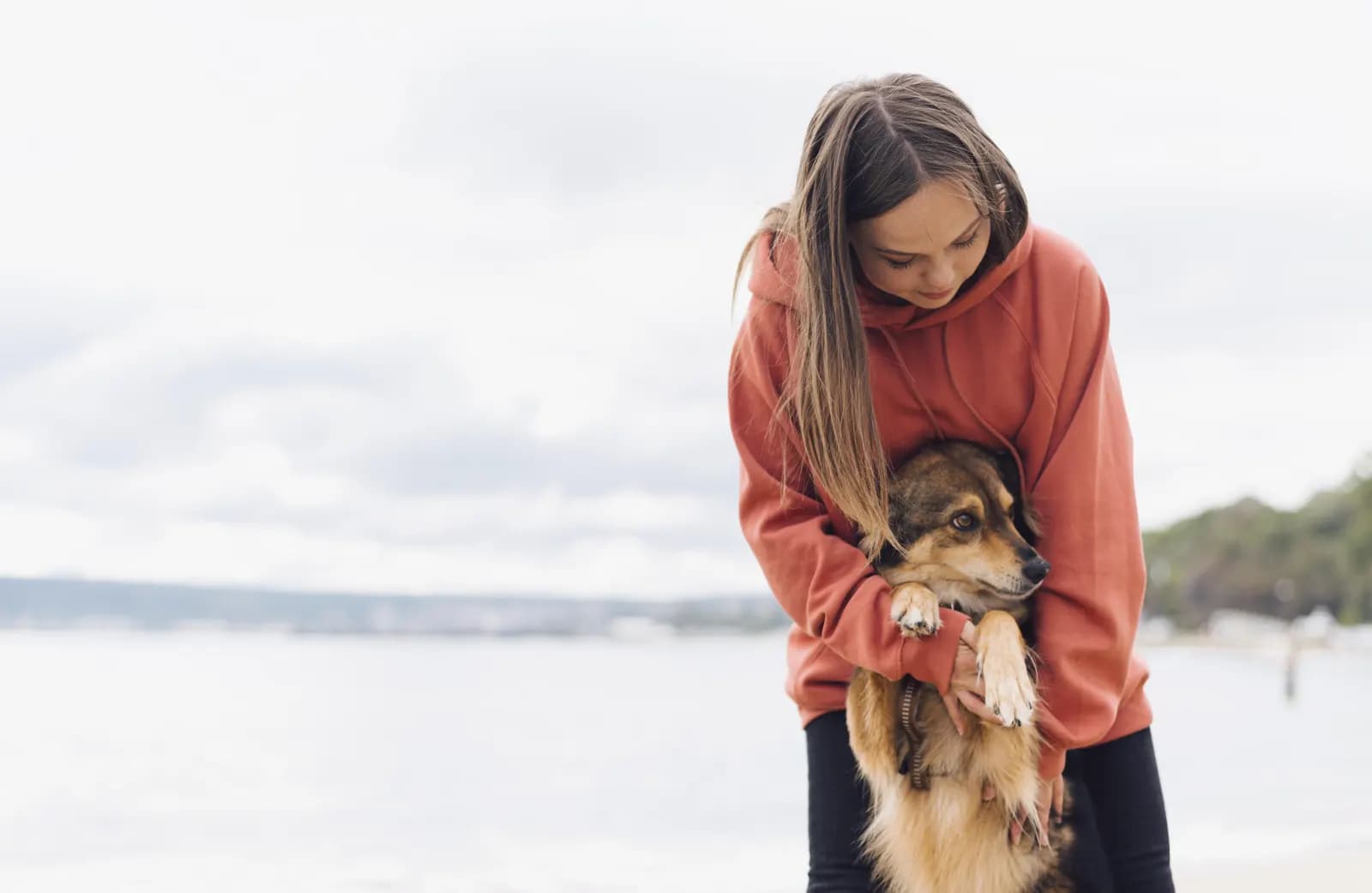Vrouw met haar hond op het strand