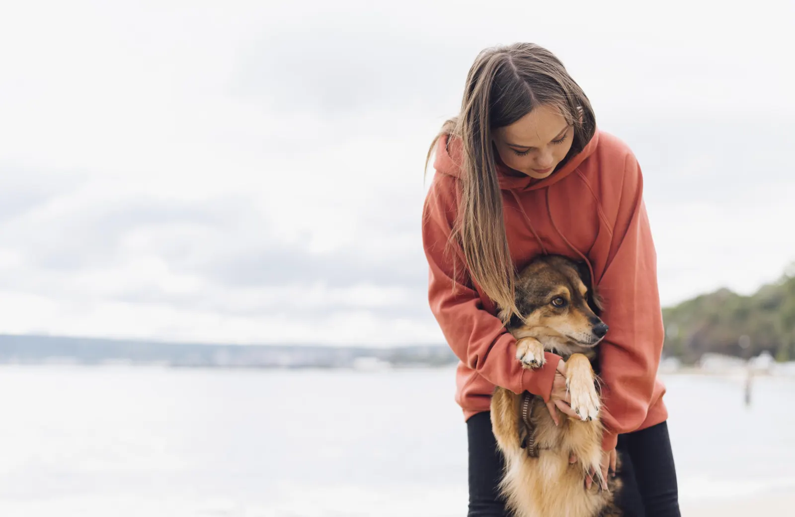 Vrouw met haar hond op het strand